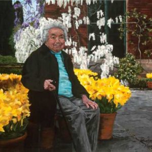 old woman seated on bench in front of yellow flowers