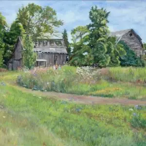 Faded gray barn surrounded by flowers and trees