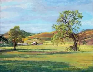 Barn and stalls in meadow trees in foreground and rolling hills in background