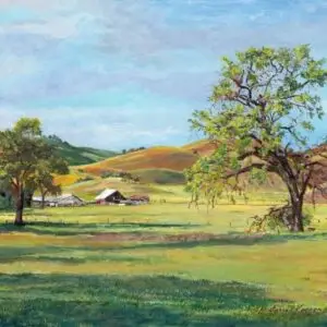 Barn and stalls in meadow trees in foreground and rolling hills in background